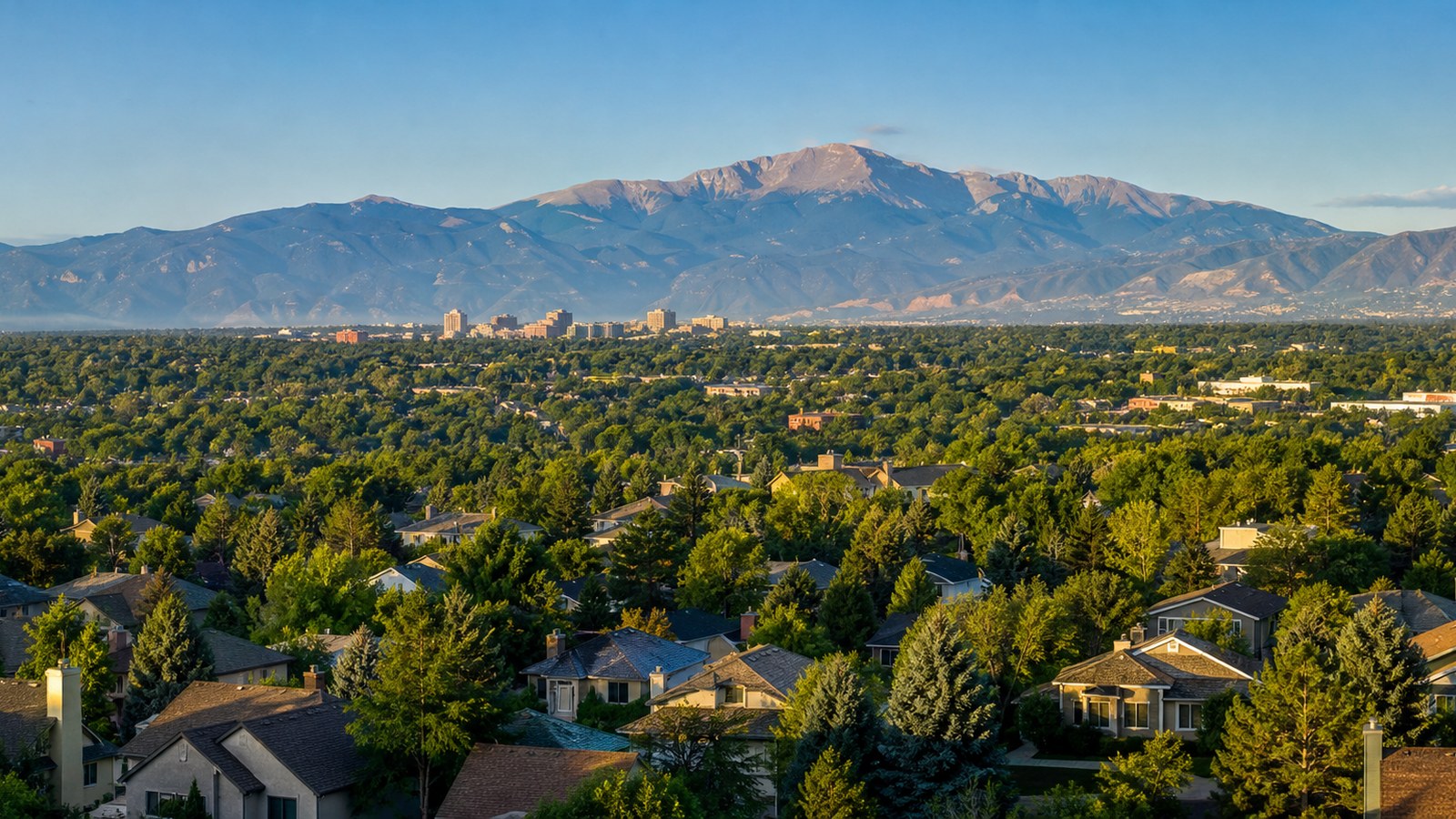 Conceptual Colorado Springs city-and-foothills scene with Pikes Peak-inspired Front Range views